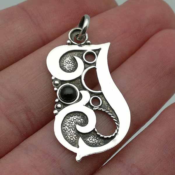 Silver pendant with the letter J.