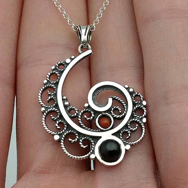 Pendant, made in the shape of a spiral, in sterling silver, jet and coral.