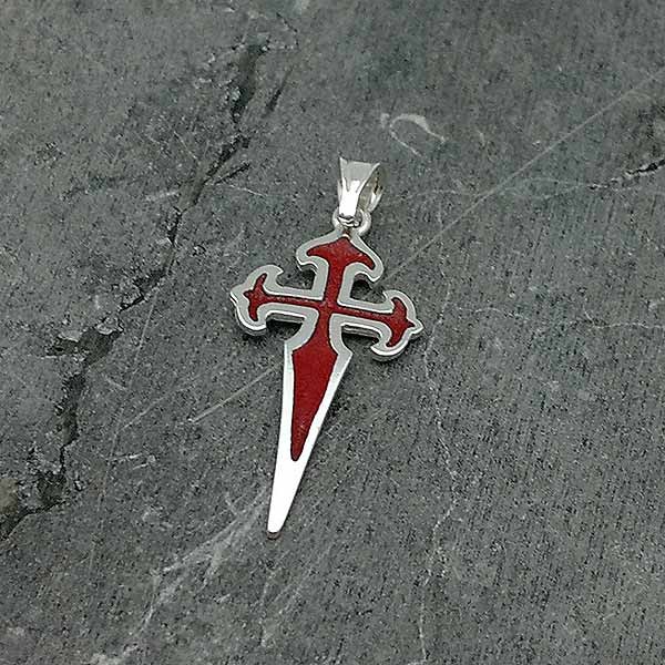 Colgante en plata de ley y esmalte al fuego, con la forma de la cruz de Santiago de Compostela.