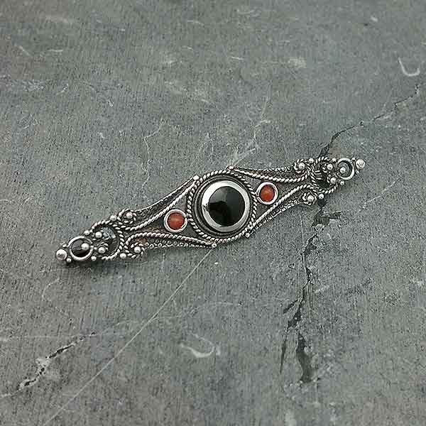 Classic style brooch, in sterling silver, jet and coral.
