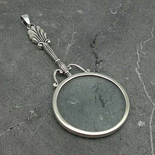 Pendant in sterling silver, shaped like a magnifying glass.