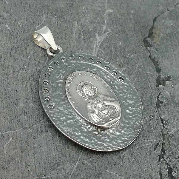 Pendant in sterling silver, with the Virgin of Fatima on the front and the sacred heart of Jesus on the back.