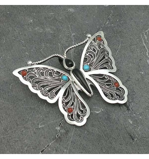 Broche con la forma de una mariposa, elaborado a mano en plata de ley y piedras naturales.