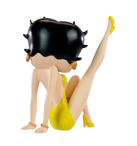 Betty Boop con vestido amarillo, posa con la pierna derecha levantada.