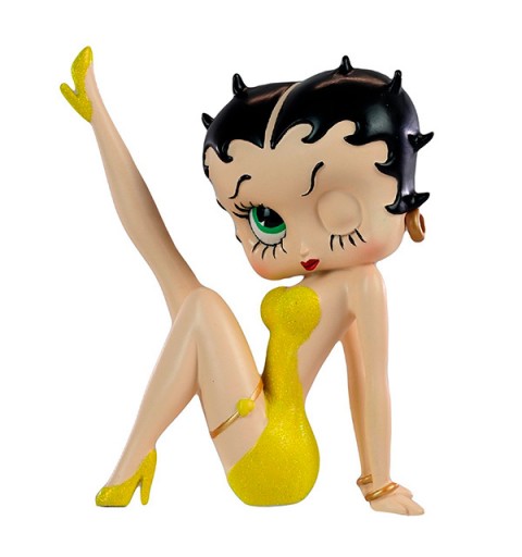 Betty Boop con vestido amarillo, posa con la pierna derecha levantada.